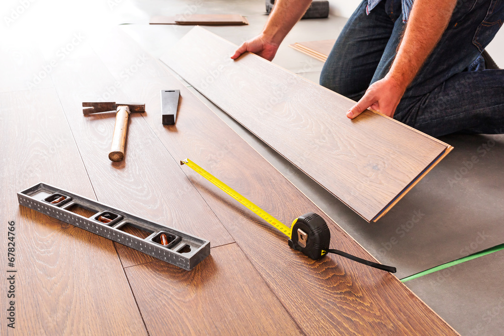Man installing new laminated wooden floor - obrazy, fototapety, plakaty 