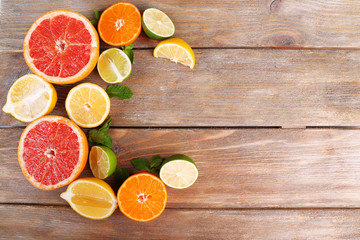 Different sliced juicy citrus fruits on wooden table