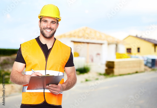 Fotografía Young smiling builder writes on a black folder
