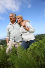 Wall Mural - Senior couple walking in countryside, scenery