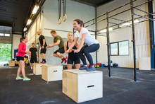 Athletes Doing Box Jumps At Gym