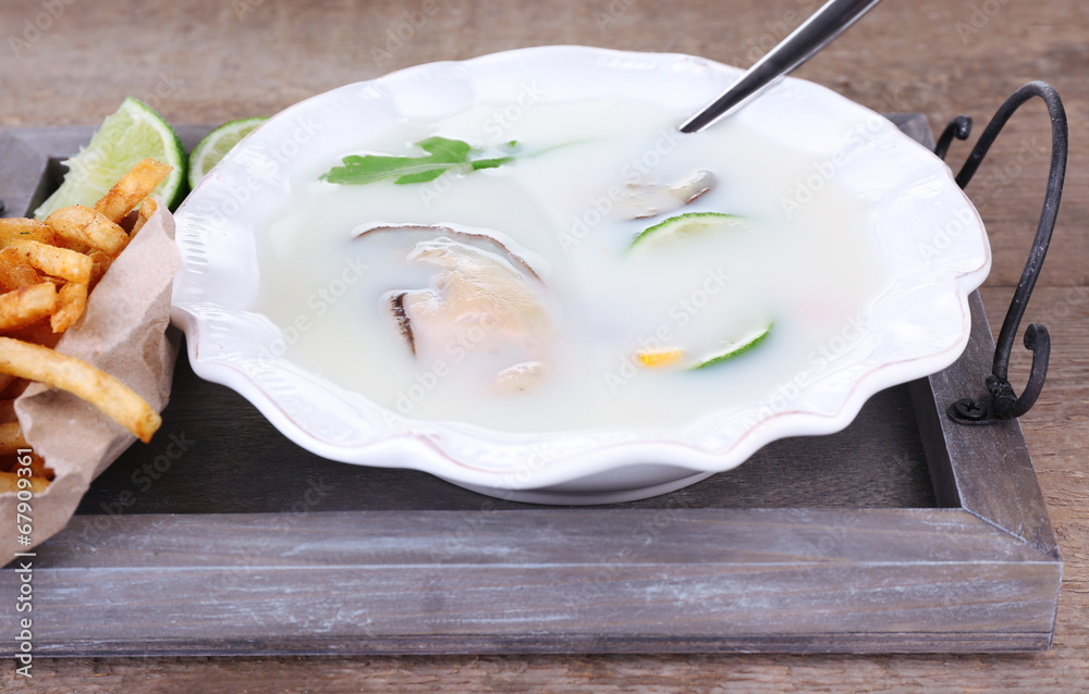 Tasty soup with oysters on wooden table