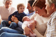 © Monkey Business - Multi Generation Family Sitting On Sofa With Newborn Baby