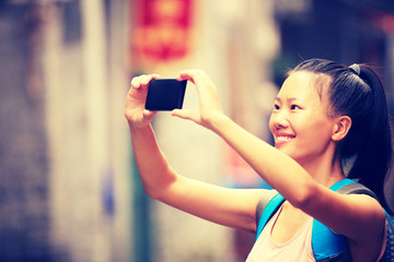 Wall Mural - woman tourist taking photo with smart phone in guilin,china 