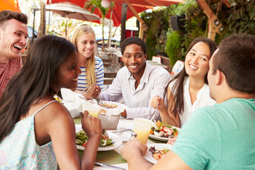 Group Of Friends Enjoying Lunch In Outdoor Restaurant