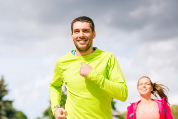 Canvas Print - smiling couple running outdoors