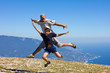 happy man and boy jumping on a background of mountains and sky a