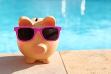 Summer Piggy Bank With Sunglasses In Front Of A Swimming Pool