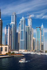 Wall Mural - Dubai Marina with boat against skyscrapers in Dubai, UAE