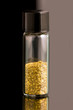 Natural placer gold and nuggets in a glass vial