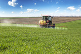 Fototapeta  - Farmer spraying wheat field with tractor sprayer