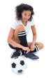 © WavebreakMediaMicro - Pretty football player in white tying her shoelace