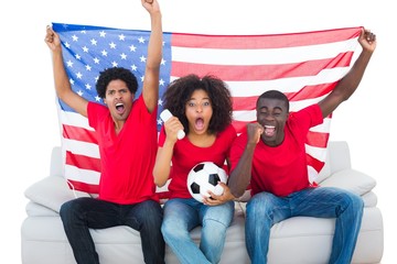 Wall Mural - Cheering football fans in red sitting on couch with usa flag