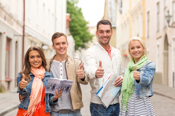 Canvas Print - group of smiling friends with city guide and map