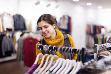 Poster - Girl choosing  wear at clothing store