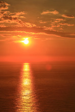 Orange Sun With Reflection On Surface Of The Sea