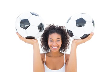 Wall Mural - Pretty girl holding footballs and smiling at camera