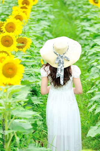 ひまわり畑に立っている白いワンピースと麦わら帽子を着ているアジア人の美しい女性 Foto De Stock Adobe Stock