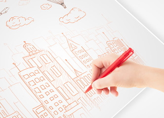 Fototapete - A person drawing sketch of a city with balloons and clouds on a