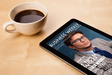 Wall Mural - tablet pc showing magazine on screen with a cup of coffee on a d