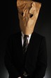紙袋で顔を隠したスーツのビジネスマン