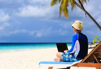 man with laptop on tropical vacation