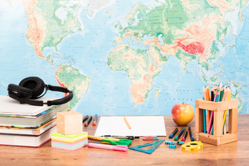 School sccessories on desktop with map at background