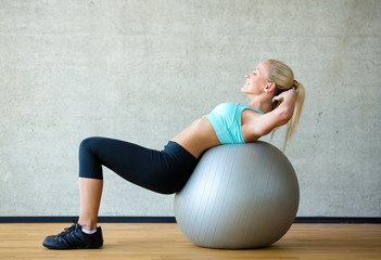 Canvas Print - smiling woman with exercise ball in gym