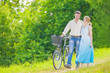 © danmorgan12 - Young Caucasian Couple Having a stroll in Park with Bike