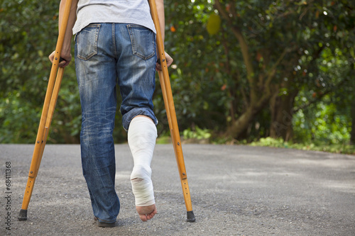 Fotografía Young asian man on crutches with tree background