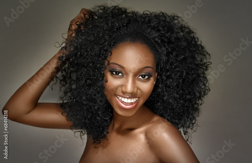 Fotografie, Obraz Young woman happy with curly hairstyle on a grey background