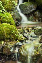 Closeup Of Waterfall Flowing Over Mossy Rocks