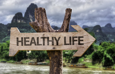 healthy life wooden sign with a forest background