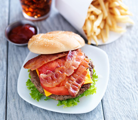 Wall Mural - cheeseburger with bacon and french fries shot overhead