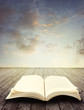 Open book on table in front of sky