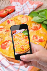 Wall Mural - Hands taking photo  pizza with smartphone