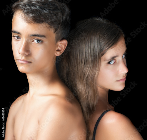 Unhappy young teen couple on a black bac