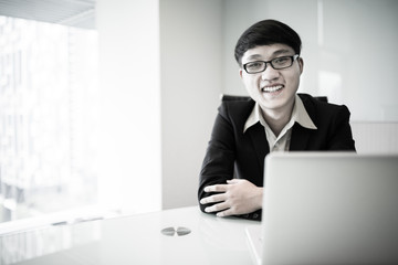 Wall Mural - Young handsome man using laptop in his office