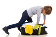 © michaeljung - young girl kneeing on suitcase trying to zip it up