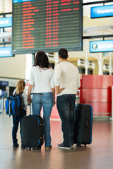 Wall Mural - family checking flight information at airport