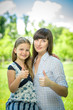 © Friends Stock - Young mother and her daughter showing thumbs up