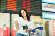 © michaeljung - woman looking at air ticket in airport