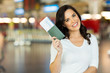 © michaeljung - young woman holding passport and boarding pass