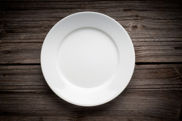 empty white plate on wooden table
