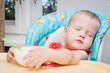© golovianko - Baby sleeping while eating at the table