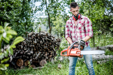 Wall Mural - portrait of aggressive, muscular and athletic man with chainsaw