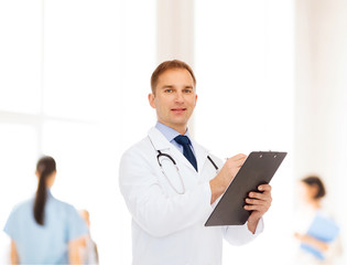 Wall Mural - smiling male doctor with clipboard and stethoscope