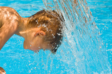 Portrait of a child under the powerful jet of water