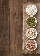 Assortment Of Legumes In Bowls On Wooden Table