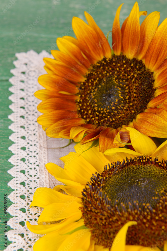 Beautiful sunflowers in pitcher on napkin on table close up